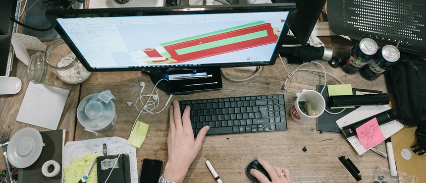 person using computer on brown wooden table - Robert Bye - unsplash 